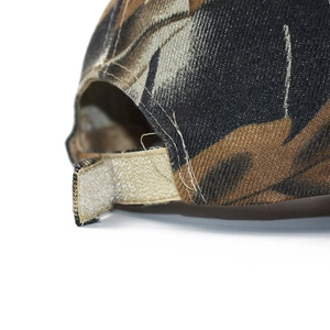 Dettaglio del cappellino mimetico da baseball con chiusura a strappo regolabile
