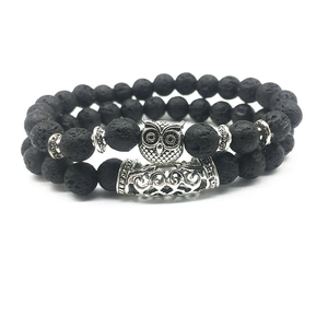 Detailed close-up of beaded owl lava stone bracelet with silver accents on white