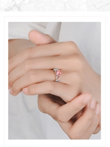 Close-up of pink strawberry quartz adjustable ring with side stones on model finger