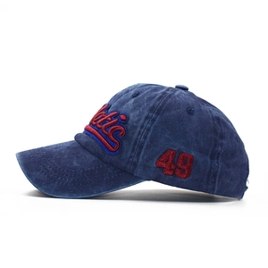Detailed close-up of red 3D embroidery on vintage washed navy denim baseball cap