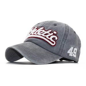 Detailed view of white Athletic 3D embroidery on washed grey cotton baseball cap