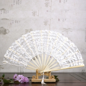 Elegant white lace folding fan with light wood ribs and a tassel on a display stand