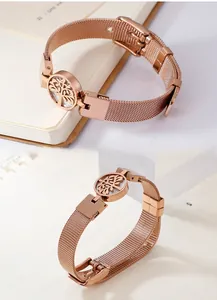 Detail of rose gold tree of life charm on mesh strap bracelet with watch style clasp
