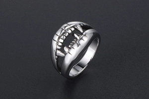 Detailed macro view of silver steel crocodile tooth ring with polished finish