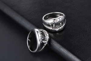 Macro shot of silver crocodile teeth ring with polished finish on black leather