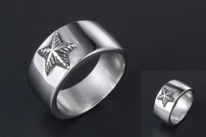 Gros plan sur bague large en acier titane argenté avec motif étoile pentagramme en relief