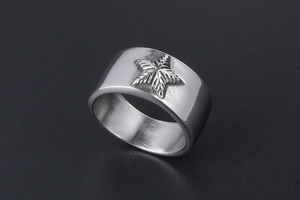 Macro d'une bague large en acier argenté avec motifs d'étoiles en relief et texture métallique