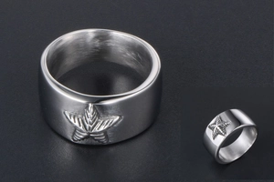 Détail macro d'une bague large en titane argenté avec motif étoile de mer gravé