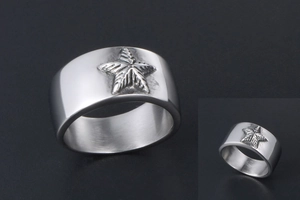 Gros plan sur une bague large argentée avec un relief en étoile de mer en acier poli