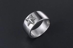 Vue macro de la bague large en acier inoxydable argenté avec motif d'étoile gravé