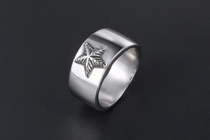 Vue détaillée d'une bague large en acier inoxydable avec motif d'étoile gravé sur l'anneau