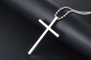 Detailed view of a silver titanium steel cross pendant on a classic bead chain