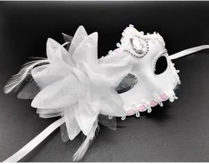 Detailed view of white masquerade mask with mesh flower, feathers, and silver bead trim