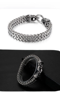 Detailed view of punk style double wolf head closure on stainless steel wheat chain bracelet