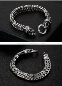 Detail of wheat braided stainless steel chain with skull head carvings and round clasp