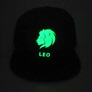 Glow-in-the-dark green Leo lion graphic and text on a black fashion baseball cap