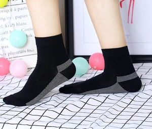 Détail de chaussettes en tricot noir antibactérien avec rayures grises portées par un mannequin
