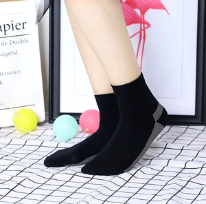 Détail de chaussettes noires en fibre de cuivre anti-odeur portées sous un angle de 45°