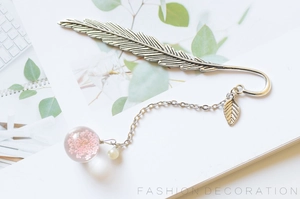 Silver feather metal bookmark featuring a round glass pendant with pink dried flowers