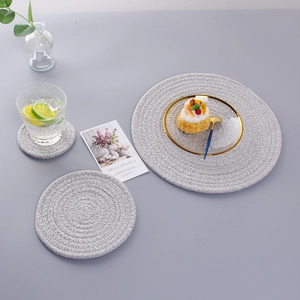 Three sizes of round woven light gray cotton coasters for heat insulation on dining tables
