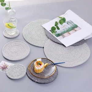 Detail of round woven cotton table mats in dark and light grey for home dining decor