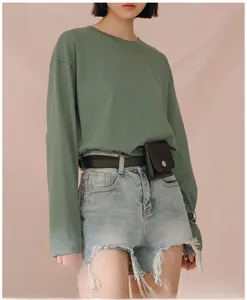 Close-up of a stylish black fanny pack belt accessory on light blue distressed denim shorts