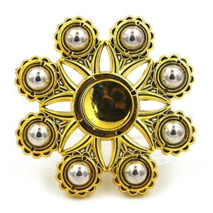 Golden flower metal brooch with radiant hollow petals and silver sphere accents on white background