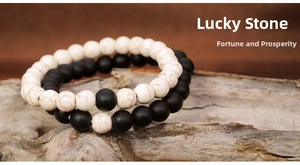 Detail view of 8mm black and white pine stone elastic bracelets on natural wood texture