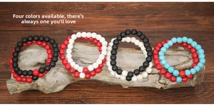 Detail view of 8mm bead bracelets in black, white, and red on a rustic wood background