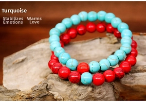 Detail of 8mm turquoise and red gemstone stretch bracelets on a rustic wood stand