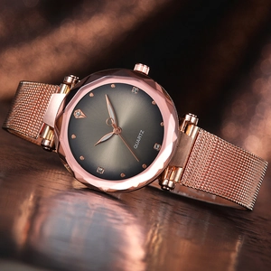 Makroaufnahme einer roségoldenen Netzuhr mit facettiertem Glas und Diamantbesatz