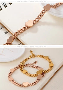 Dettaglio di bracciali con chiusura a cuore in oro e oro rosa su un taccuino crema