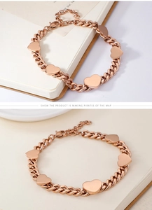 Dettaglio del braccialetto a cuore in oro rosa con maglie a catena su un libro bianco