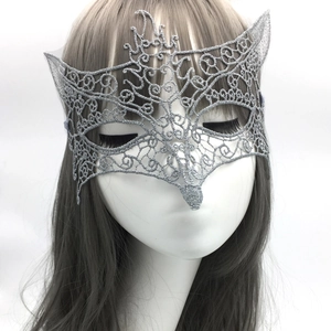Close-up of silver embroidered lace masquerade mask showing intricate phoenix patterns