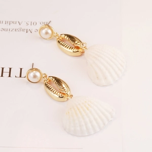 Detail view of Bohemian shell drop earrings with white pearl and golden conch pendant
