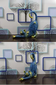 Detail of creative blue cat resin statue with gold accents in a stretching pose