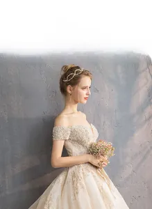 Detail of luxury off-the-shoulder champagne wedding dress with beaded lace and embroidery