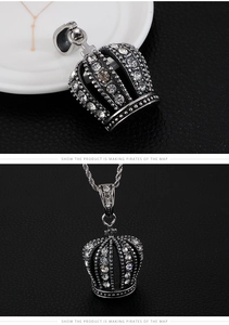Close-up of iced out crown pendant with silver finish and micro paved rhinestones