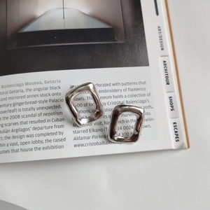Detailed view of irregular rectangular 925 sterling silver studs on a fashion magazine