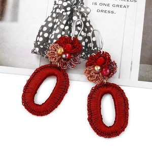 Detail of red Bohemian crochet flower earrings with vibrant beads and silver metal hooks