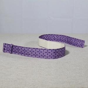 Detail view of purple floral fabric bake even strip for level cake baking on linen background