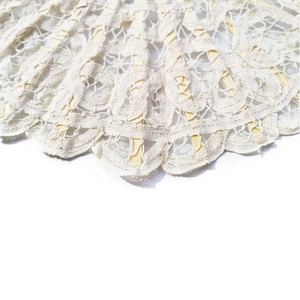 Detailed close-up of beige lace fabric and carved wooden ribs on a vintage folding fan