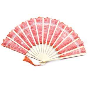Detail of an orange lace hand fan with bamboo ribs and a matching silk tassel