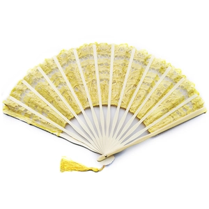 Detail of yellow lace folding fan with intricate floral patterns and matching tassel