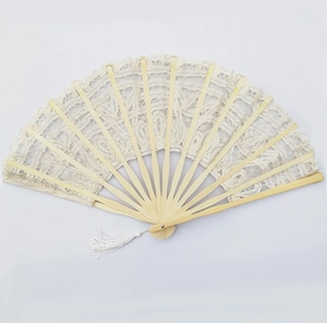 Detailed close-up of a vintage beige lace folding fan with intricate embroidery and tassel
