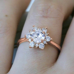 Gros plan d'une bague flocon de neige en or rose avec zircons sur une main
