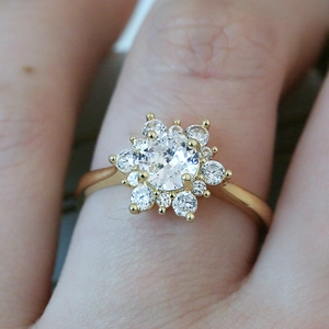 Bague flocon de neige en or avec pierre ronde et zircons brillants sur le doigt