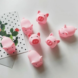 Detailed view of seven pink squeeze pig toys on a clean white surface with card