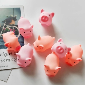 Close-up of eight cute pink pig squeeze toys on white background with decorative cards