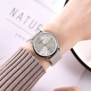Gros plan d'une montre à bracelet argenté et cadran gris brossé au poignet d'une femme